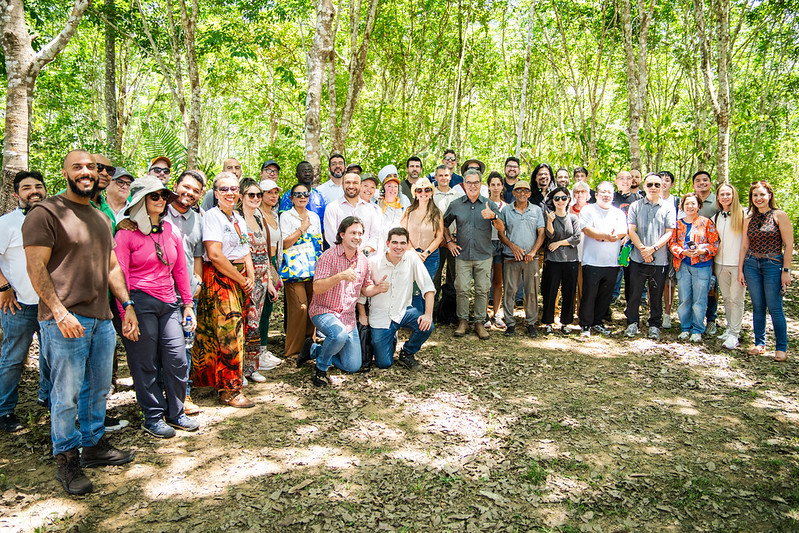 Grupo de compradores internacionais e representantes de empresas brasileiras reunidos em meio à natureza durante o programa Exporta Mais Brasil na Amazônia.
