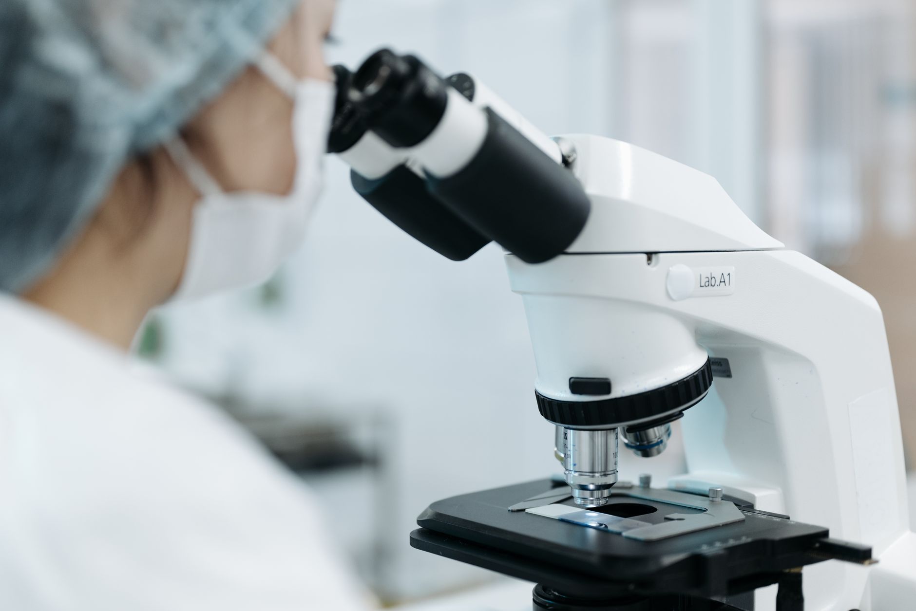 medical professional looking through a medical microscope